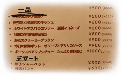 Photo of a Japanese restaurant menu listing dishes such as 海老のクリーミーグラタン and 柚子シャーベット with their prices.